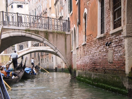 Gondola passing under arched bridges